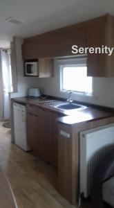 a kitchen with a sink and a stove top oven at Serenity Seton Sands in Longniddry