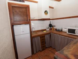 cocina con nevera blanca y microondas en Cases dels Gasulla en Chiva de Morella