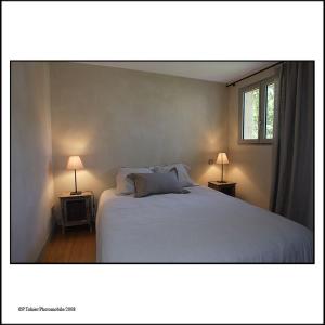 a bedroom with a white bed and two lamps at Narbaitz Vacances in Saint-Jean-Pied-de-Port