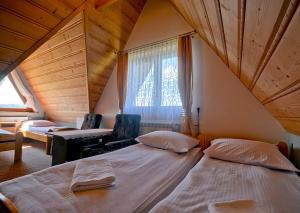 ビャウカにあるDom Wypoczynkowy Skorusaのベッドルーム(ベッド2台付)が備わる屋根裏部屋です。