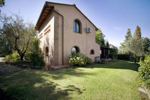 a large house with a grass yard in front of it at Villa La Capinera in Montopoli in Val dʼArno