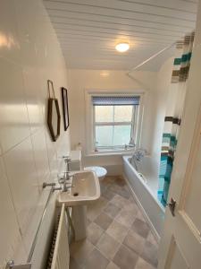 La salle de bains est pourvue d'un lavabo, d'une baignoire et de toilettes. dans l'établissement Ashington Home from Home, à Ashington