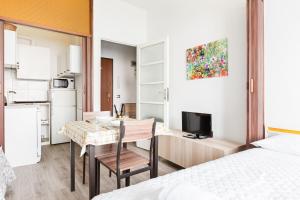 Apartamento pequeño con cocina, mesa y cama en Milano Cozy Studio, en Milán