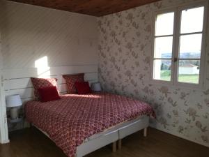 a bedroom with a bed with red pillows and a window at Le Galaveyson in Le Grand Serre