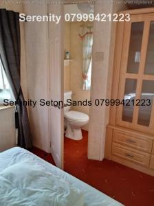 a bedroom with a bed and a bathroom with a toilet at Serenity Seton Sands in Longniddry