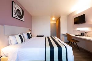 um quarto de hotel com uma cama grande e uma secretária em Hotel Atlantis em Kourou