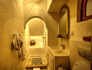 a bathroom with a sink and a toilet and a mirror at Riad Aventurine in Marrakesh