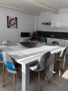 a kitchen with a white table and chairs at Maxima Sunset in Sainte-Maxime