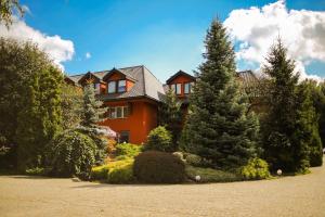 a large orange house with trees in front of it at Agat Hotel in Łódź
