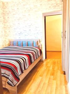 Un dormitorio con una cama con una manta a rayas. en Apartment near the sea 1, en Kobuleti