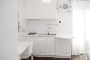 a kitchen with white cabinets and a sink at Casa San Vito in Monopoli