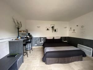 a bedroom with a bed and a desk in it at Le Beauvaisis in Esches