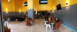 a large room with tables and chairs and a television at GATE 14 Inn in Nakhon Phanom