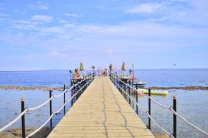 een houten pier met mensen op het water bij Xperience Sea Breeze Resort in Sharm El Sheikh