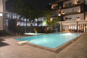 a swimming pool in front of a building at night at Grand Cordela Hotel AS Putra Kuningan in Kuningan
