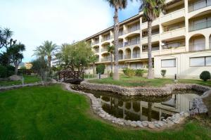 a hotel with a pond in front of a building at JARDINS DEL MAR 25 in L'Estartit