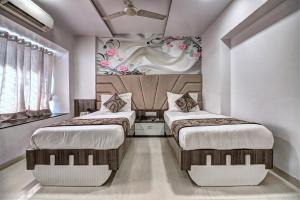 two beds in a room with white walls at Hotel City View in Navi Mumbai +90 photos