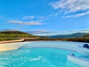 a swimming pool with blue water and a view at The Stables in Monmouth