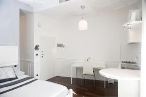a white room with a bed and a desk and a table at Casa San Vito in Monopoli +26 photos
