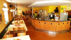 a restaurant with a counter and tables and chairs at MB Hotel Weißer Hirsch in Hohnstein