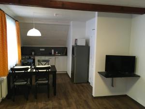 eine Küche und ein Esszimmer mit einem Tisch und einem Kühlschrank in der Unterkunft Apartman Herman in Rudník