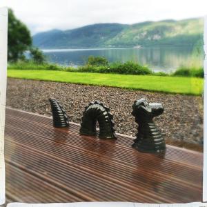 Dores的住宿－Balachladaich Loch Ness B&B，一张坐在长凳上的两只狗的雕像