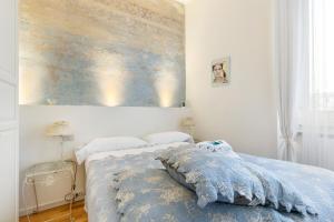 una camera da letto con un letto e un dipinto sul muro di Naviglio Pavese Cosy Apartment a Milano