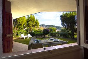 a view from a window of a patio with a table and chairs at Sa Tirìa in Chia