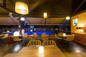 un restaurant avec des tables, des chaises et des lumières dans l'établissement Hotel Atlantis, à Kourou