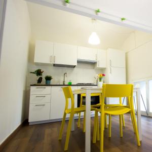 een keuken met gele stoelen en een tafel bij Casa MaMo 36 in Palermo