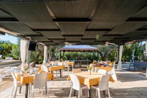 an outdoor patio with tables and chairs at B&B Villaggio Regina in Matino