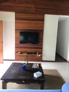a living room with a tv and a coffee table at Casa na praia , Ar c, pisc,bosque , dunas e lagoa in Florianópolis