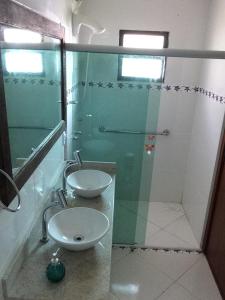 a bathroom with a glass shower and a sink at Casa na praia , Ar c, pisc,bosque , dunas e lagoa in Florianópolis