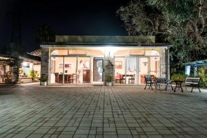 a building with chairs and a patio at night at B&B Villaggio Regina in Matino