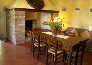 uma sala de jantar com uma mesa de madeira e cadeiras em Villa Vallocchie em Sarteano