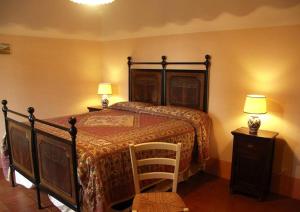 um quarto com uma cama, 2 candeeiros e uma cadeira em Villa Vallocchie em Sarteano