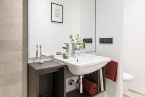 a white bathroom with a sink and a toilet at ipartment Hamburg HafenCity in Hamburg +26 photos