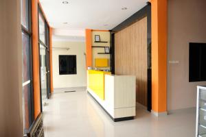 an office corridor with a yellow and orange wall at OYO 1149 Hotel Mustika in Tanjungpandan