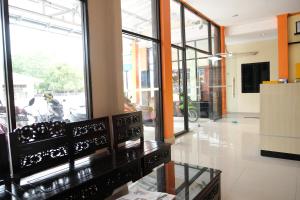 a lobby with a table in a building with windows at OYO 1149 Hotel Mustika in Tanjungpandan