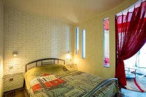 ein Schlafzimmer mit einem Bett und einem roten Vorhang in der Unterkunft Люкс студия 1 комнатная,в центральном районе города in Mykolajiw