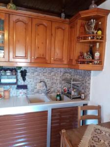 una cocina con armarios de madera y fregadero en Mitsani Country House, en Ágios Matthaíos