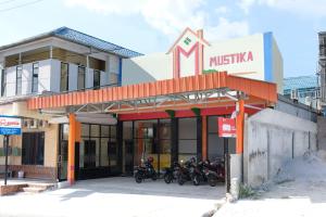 een groep motorfietsen geparkeerd voor een museum bij OYO 1149 Hotel Mustika in Tanjungpandan