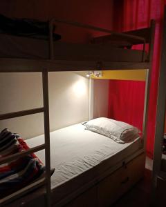 1 dormitorio con 2 literas y 1 cama blanca en The Desire Hostel, en Nueva Delhi