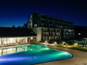 una piscina frente a un edificio por la noche en MS Pro Apartamenty De Lux Class, en Kołobrzeg