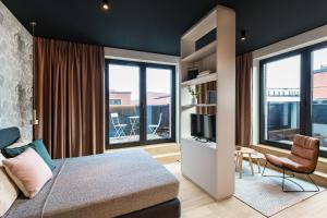 a bedroom with a bed and a tv and some windows at ipartment Hamburg HafenCity in Hamburg