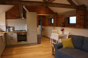 a kitchen and a living room with a blue couch at Blashford Manor Farmhouse - New Forest Cottage in Ringwood