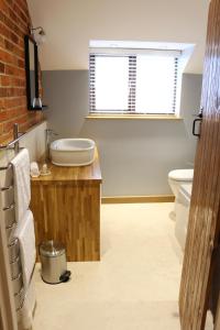 une salle de bain avec une baignoire, un lavabo et des toilettes dans l'établissement Blashford Manor Farmhouse - New Forest Cottage, à Ringwood