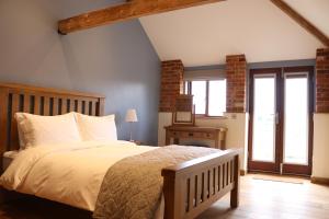 a bedroom with a large bed with white pillows at Blashford Manor Farmhouse - New Forest Cottage in Ringwood