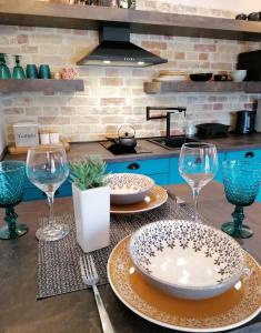 a kitchen with two plates and wine glasses on a counter at Apartman Kika in Poreč