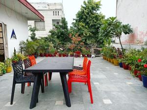 a black table with red chairs and plants at The Desire Hostel in New Delhi